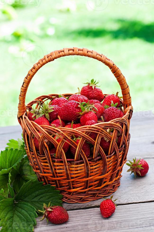 Frische Erdbeeren in einem Korb auf einem Tisch im Garten foto