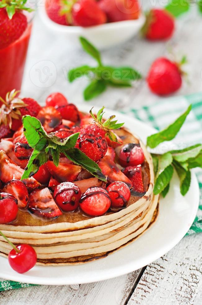 Pfannkuchen mit Beeren und Erdbeer-Smoothie im rustikalen Stil foto