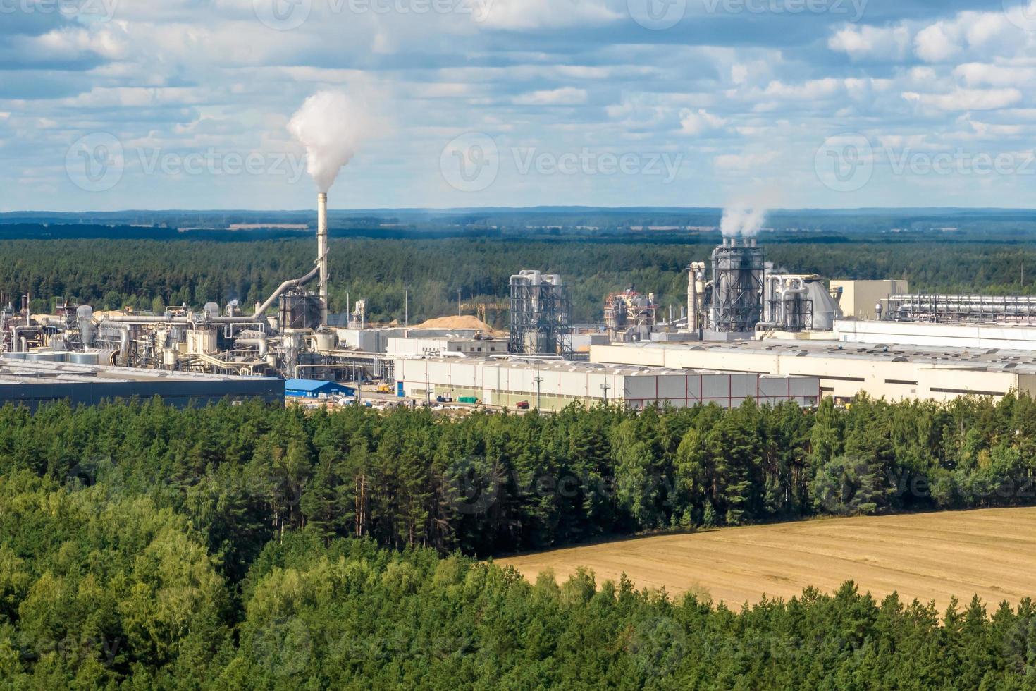 Luftbild auf Rohren des Sägewerks des Holzbearbeitungsunternehmens. Luftverschmutzungskonzept. Industrielandschaft Umweltverschmutzung Abfall foto