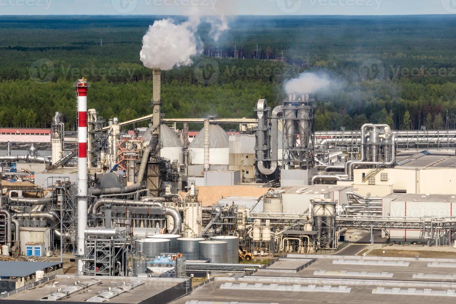 Luftbild auf Rohren des Sägewerks des Holzbearbeitungsunternehmens. Luftverschmutzungskonzept. Industrielandschaft Umweltverschmutzung Abfall foto