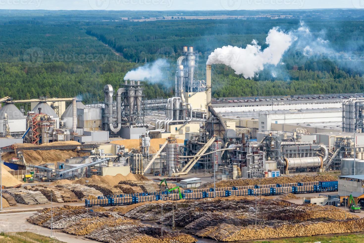 Luftbild auf Rohren des Sägewerks des Holzbearbeitungsunternehmens. Luftverschmutzungskonzept. Industrielandschaft Umweltverschmutzung Abfall foto