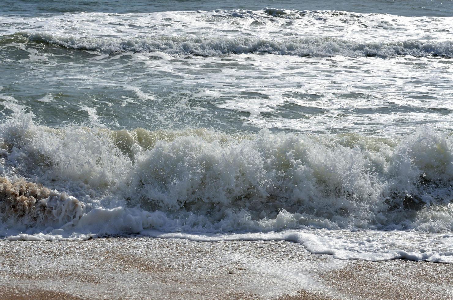 Meereswellen, die am Strand krachen foto