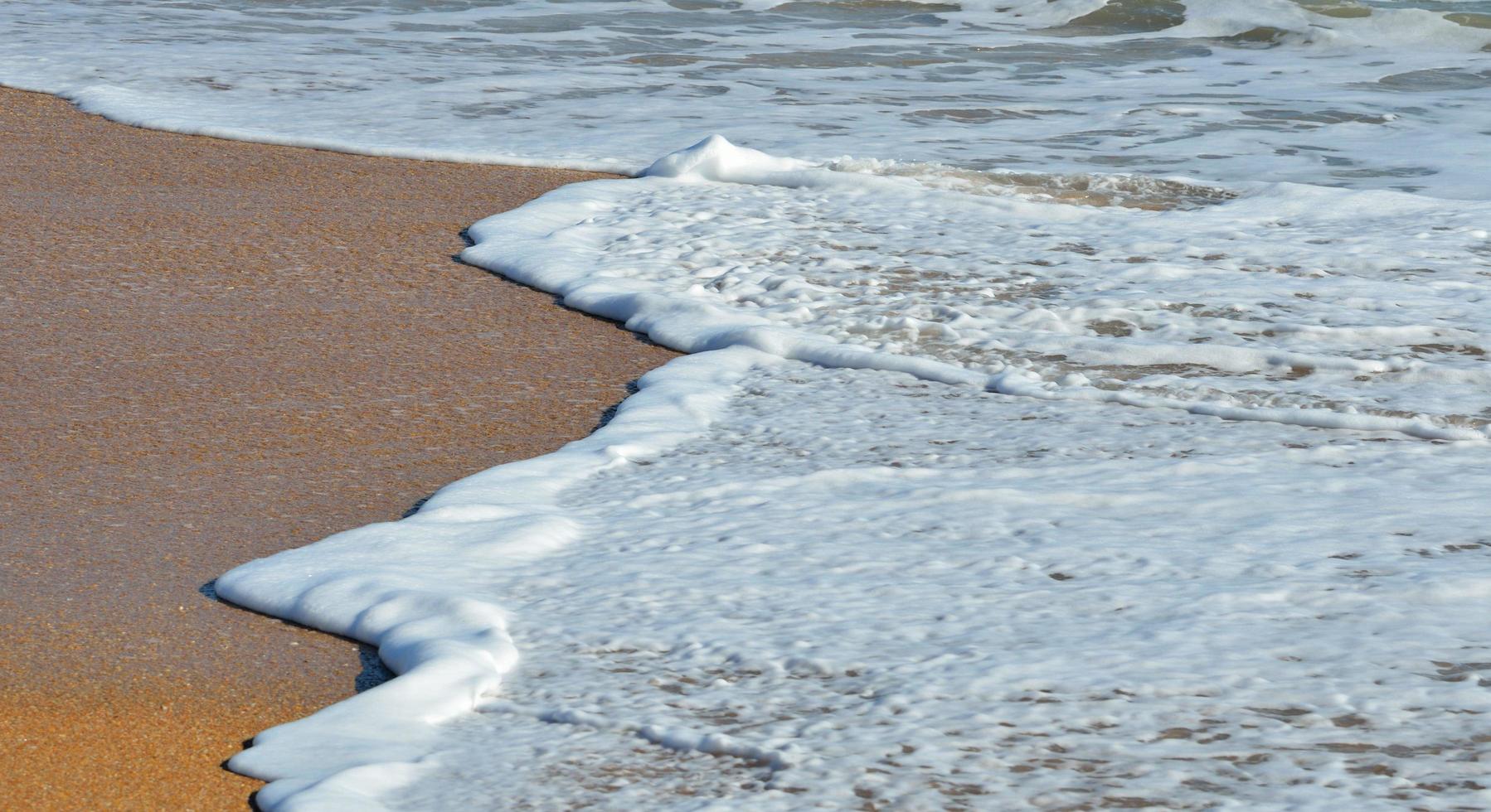 Wellen krachen am Strand foto