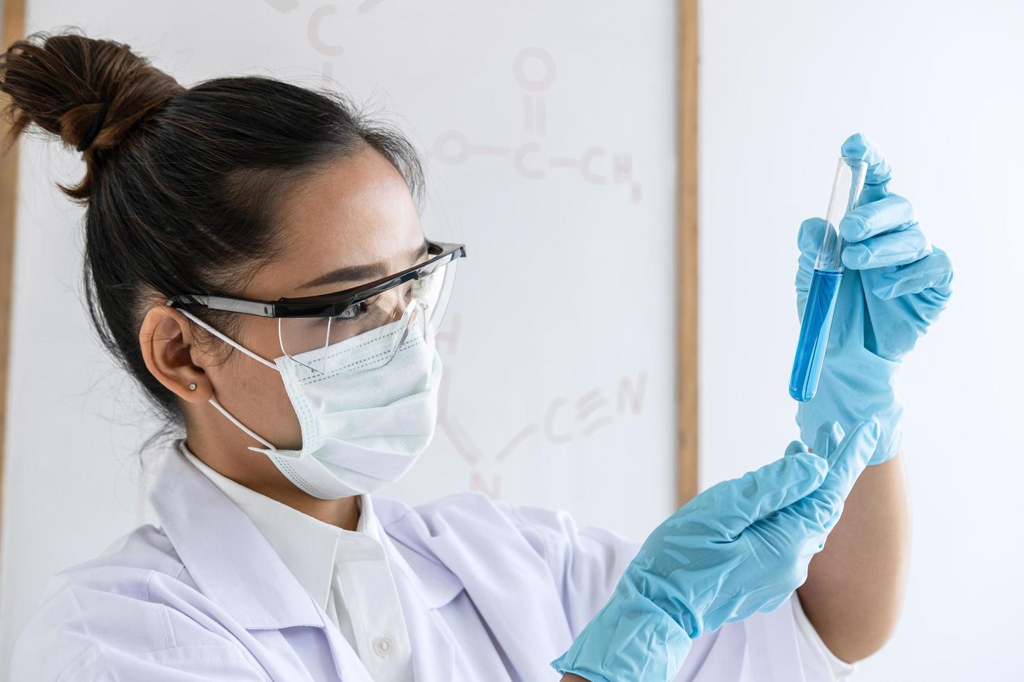 Wissenschaftler im Laborkittel mit Reagenzglas foto