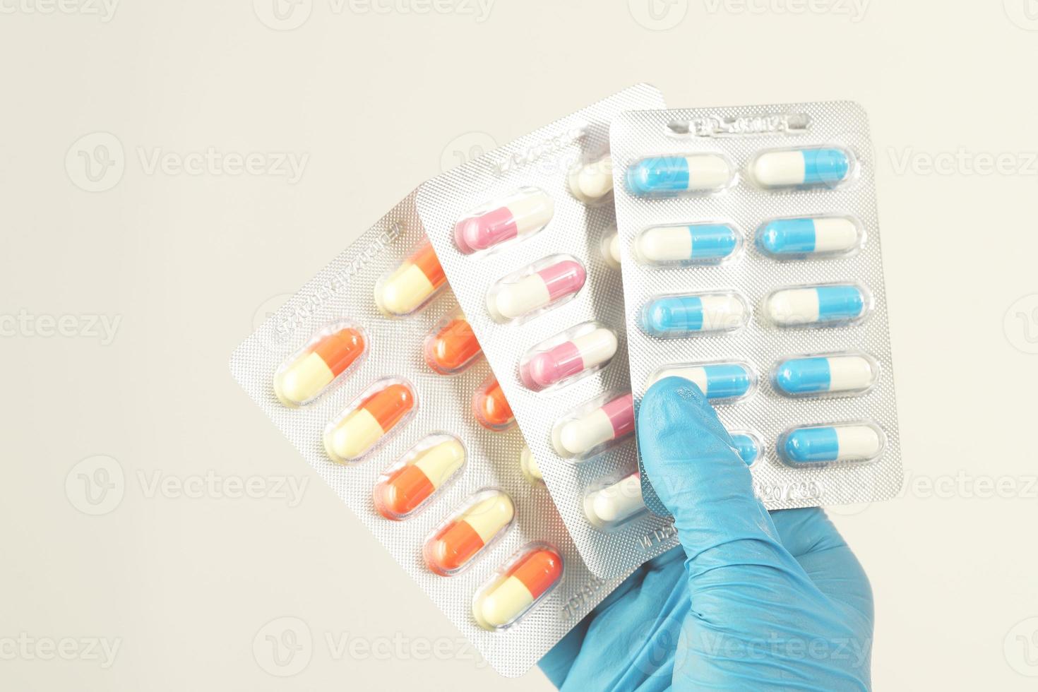 der Apotheker oder Arzt hält die Antibiotika-Kapseln und gibt sie dem Patienten oder der Person. übermäßiger Einsatz von Antibiotika antimikrobielle Resistenz weißer Hintergrund foto