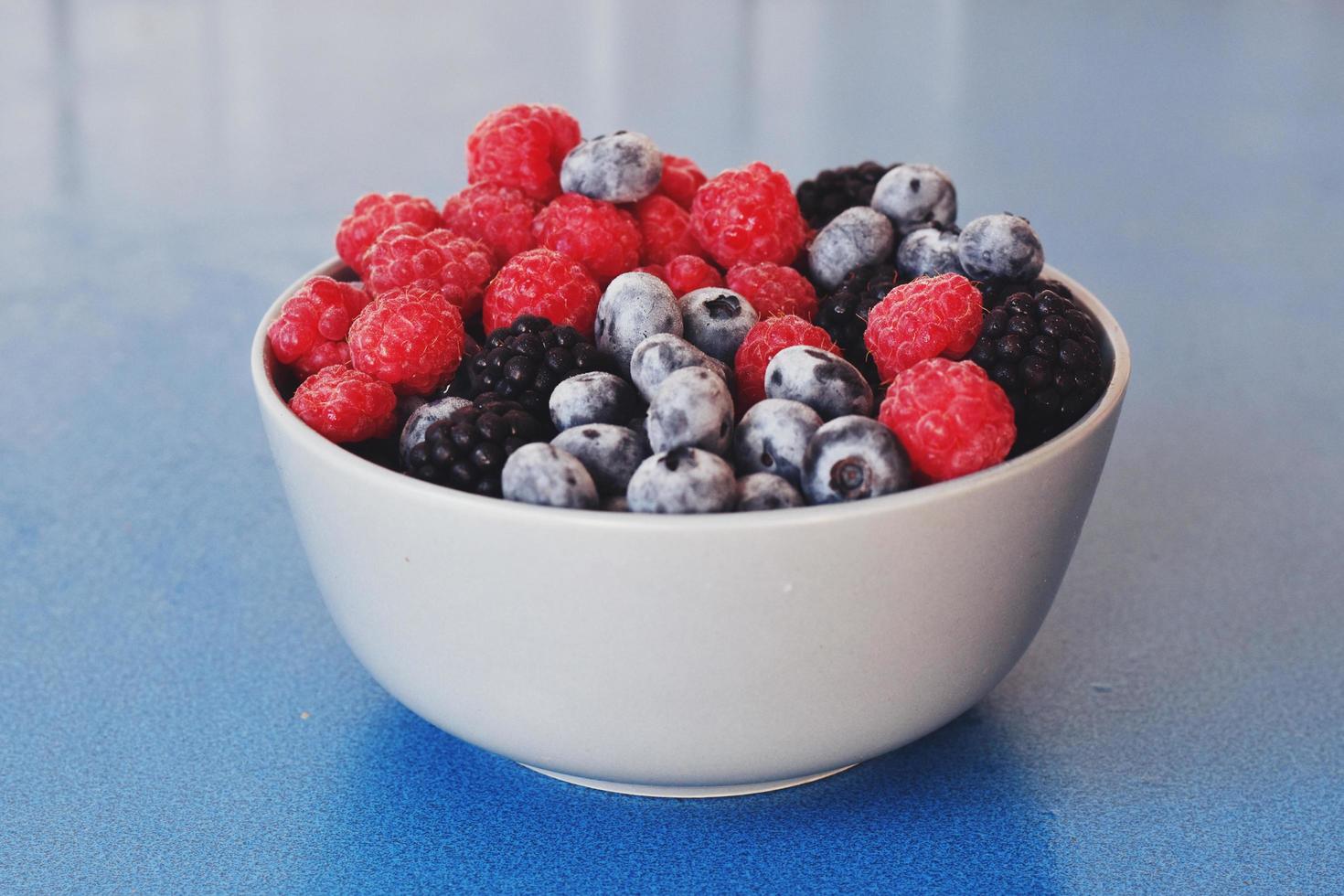 verschiedene Beeren in Schüssel, Brombeere, Blaubeere, Himbeere foto