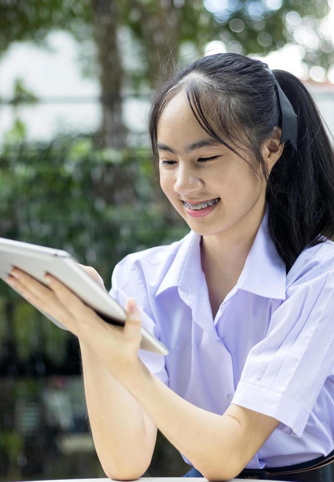 junger thailändischer Student mit Tablette foto