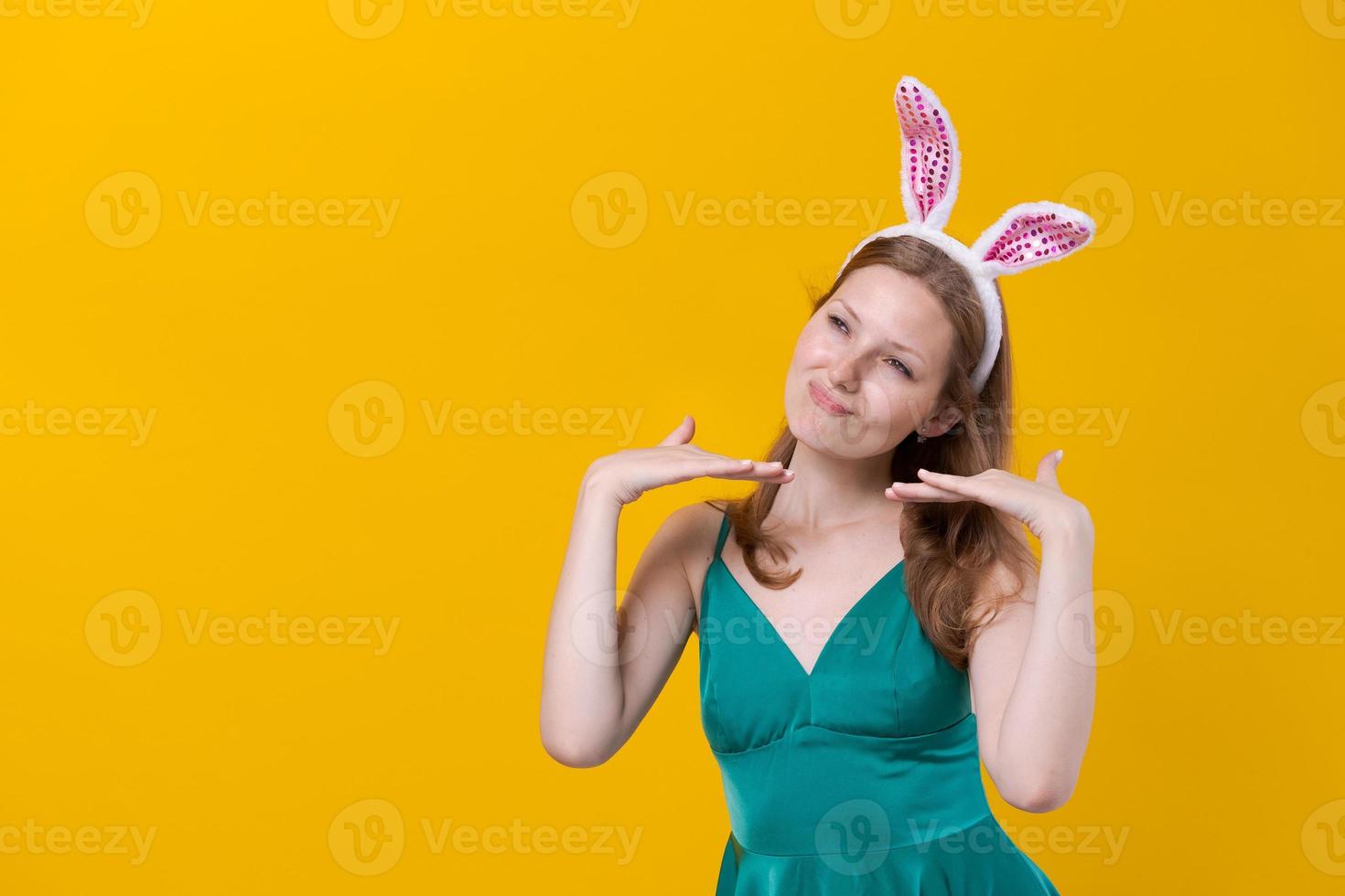 junge frau mit hasenohren für die osterferien, die lächelnd eine idee präsentieren foto