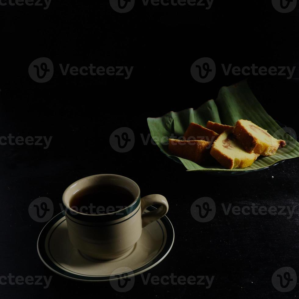 Tee und Kuchen auf schwarzem Hintergrund. teezeit zu hause konzept foto