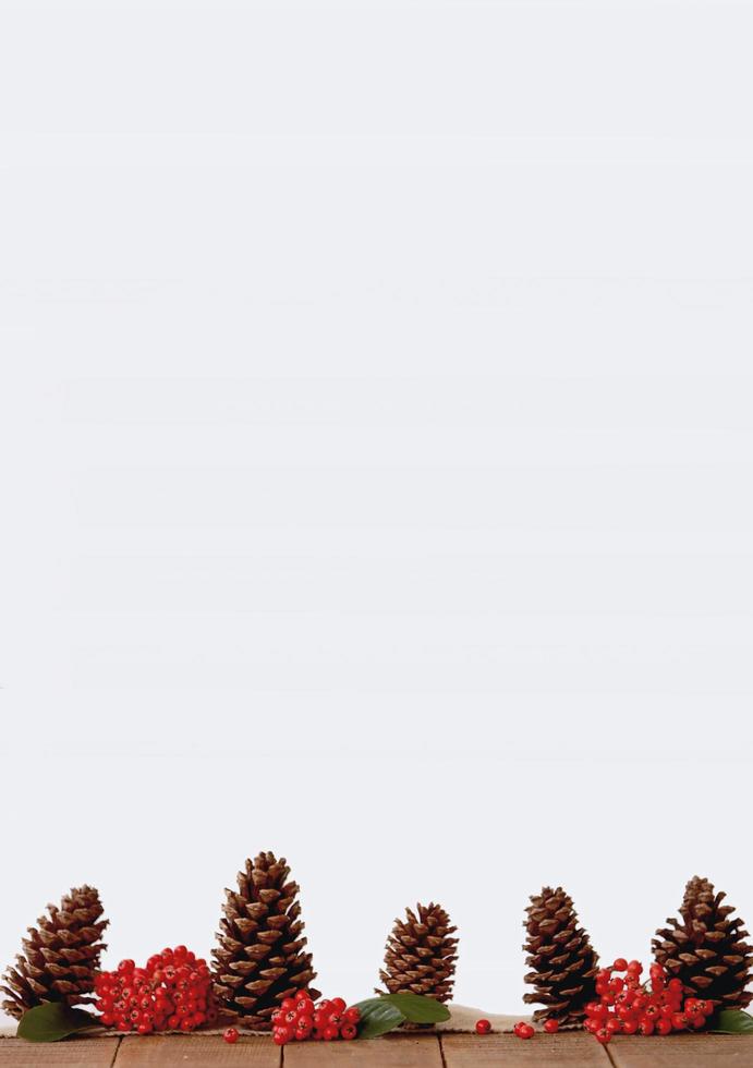 Tannenzapfen mit roten Beeren auf einem Tisch foto