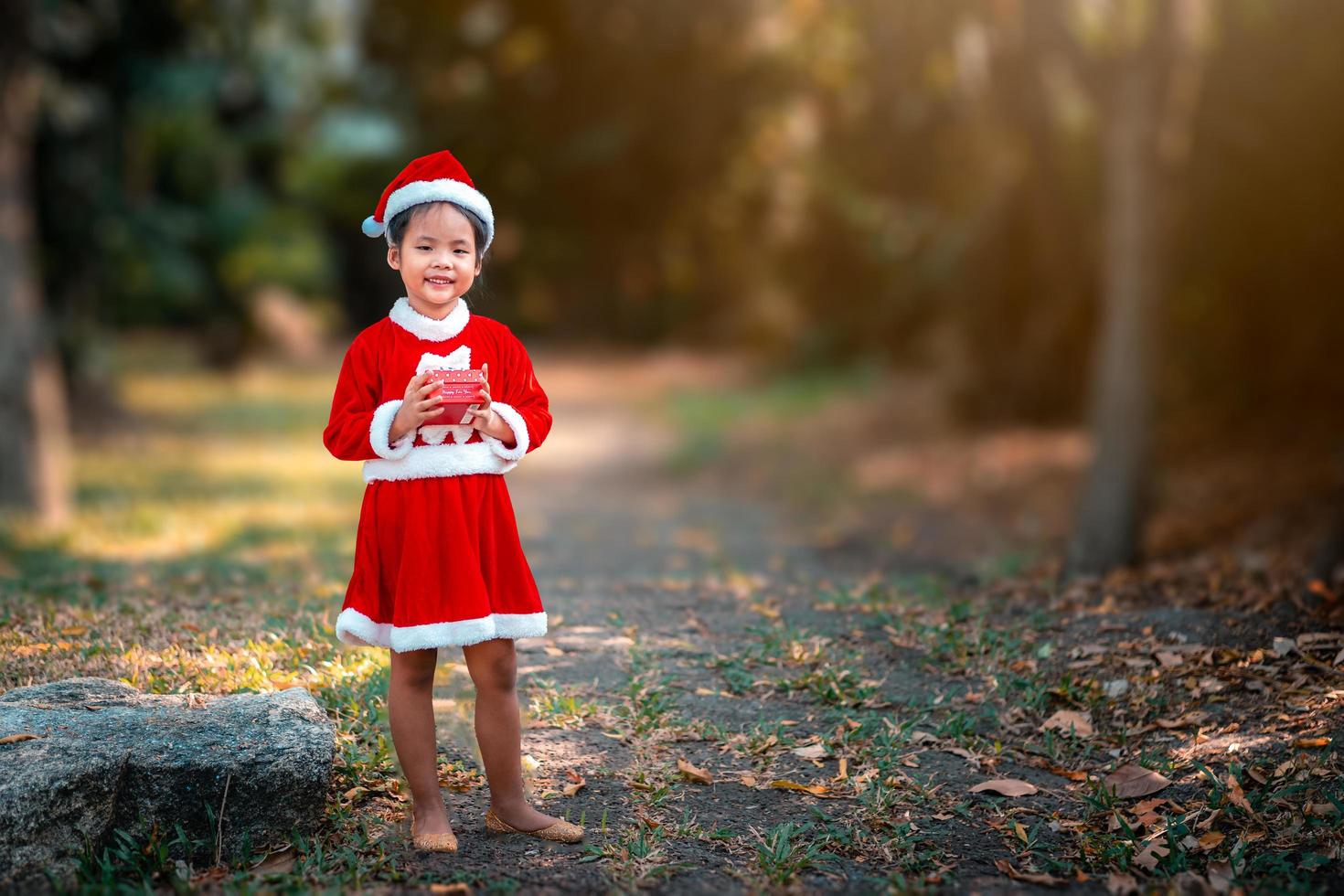 Mädchen, das ein Weihnachtsoutfit in einem Park trägt foto