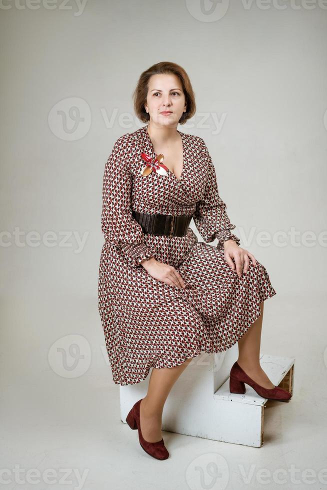 Reife Frau posiert im Studio im Hintergrund foto