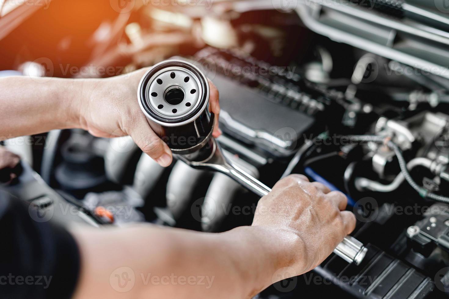 Schließen Sie den alten Ölfilter des Autos und den Schraubenschlüssel in der  Hand. Ein Mann ändert das Motorraumservice-Konzept des Autos 15011688  Stock-Photo bei Vecteezy