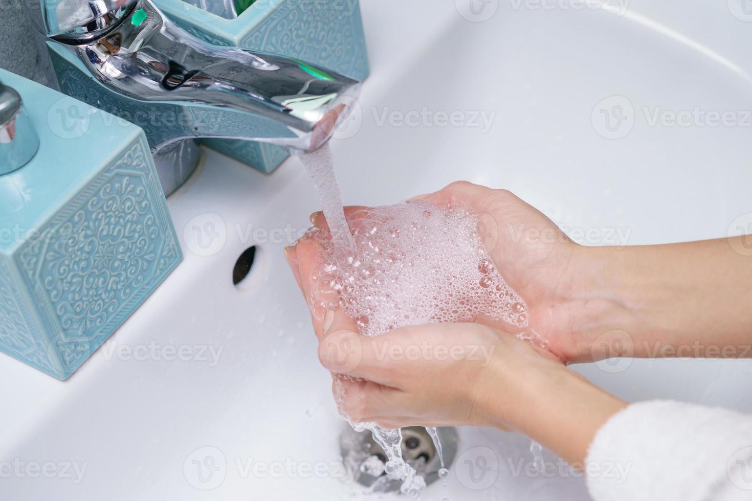 Frau wäscht ihre Hand im Waschbecken, ohne Gesicht foto