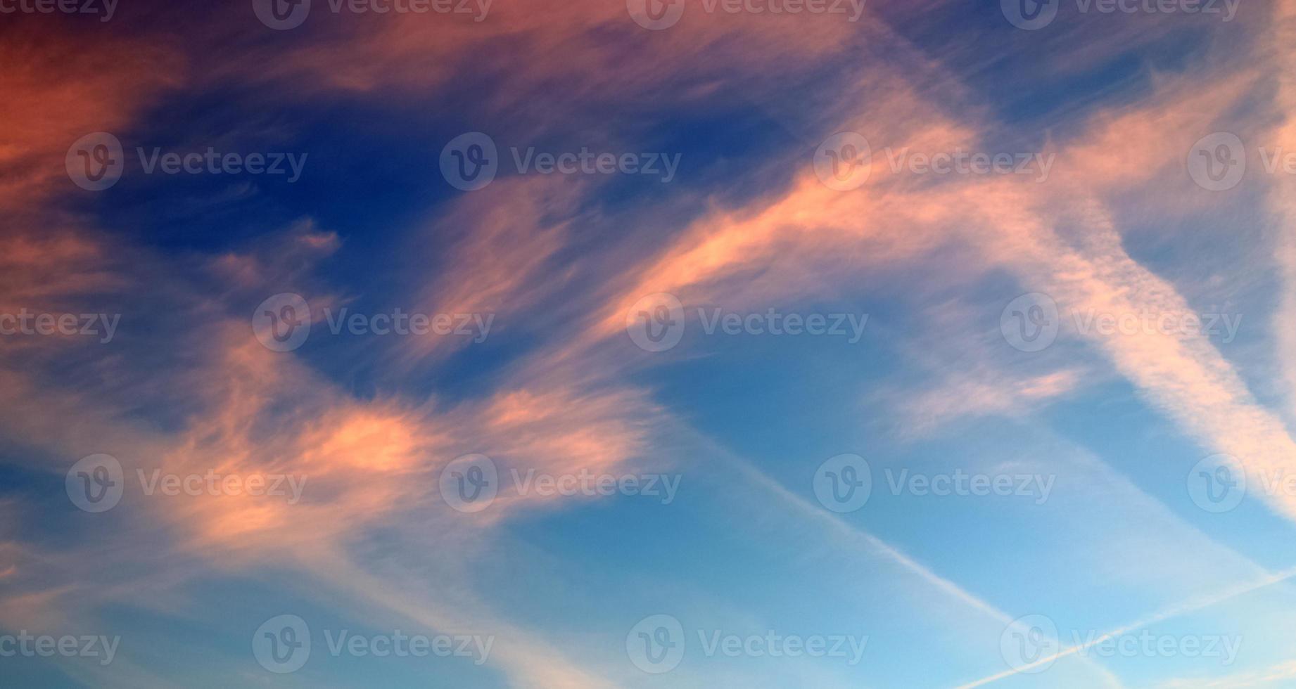 Flugzeug-Kondensstreifen am blauen Himmel zwischen einigen Wolken foto