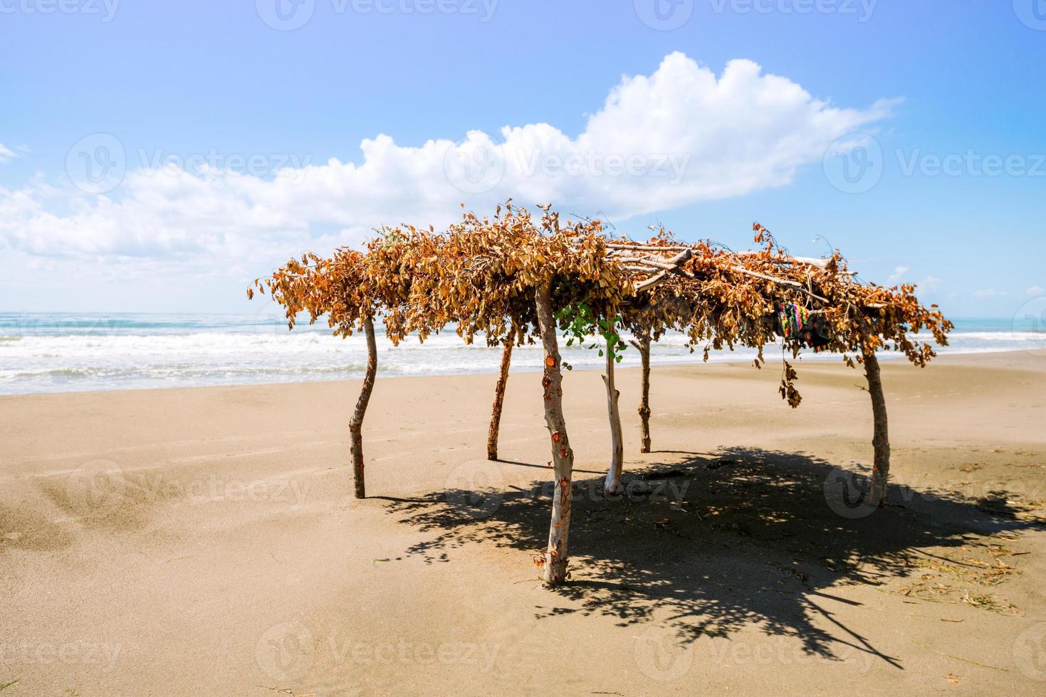 einsamer Strand und Sonnenschutz foto