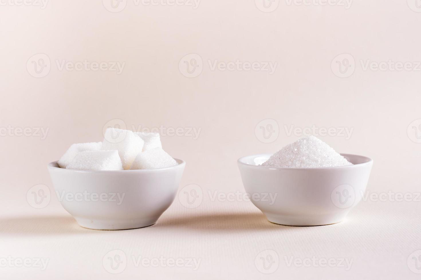 Würfelzucker und Kristallzucker in Schalen auf hellem Hintergrund. zwischen Zuckersorten wählen foto