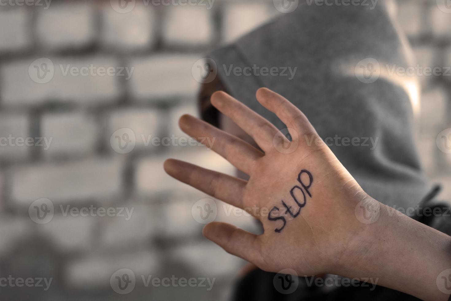 der junge schließt seine hand, geschrieben auf seiner hand stop, grausamkeit gegenüber kindern foto