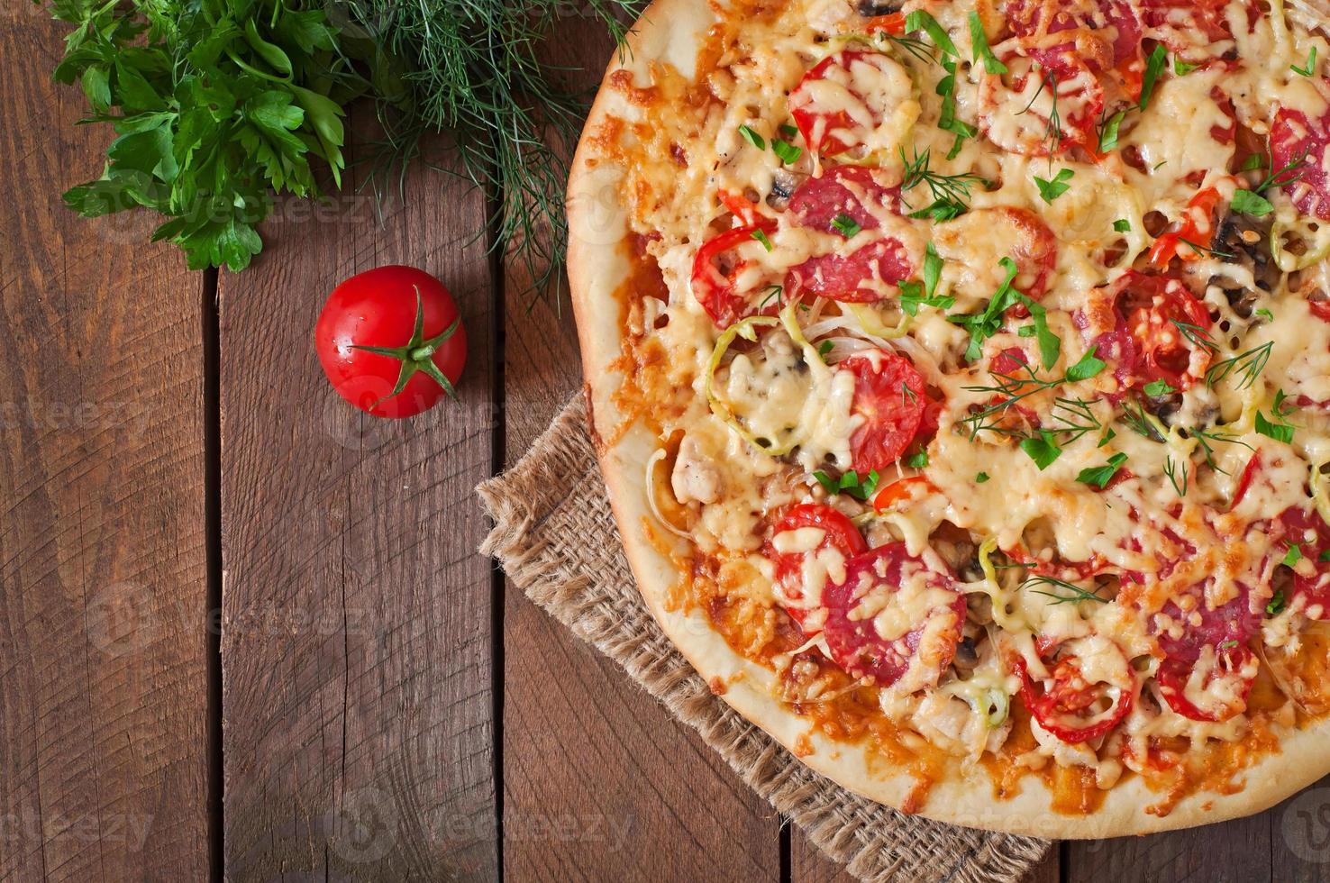 Pizza mit Salami, Tomaten und Champignons foto