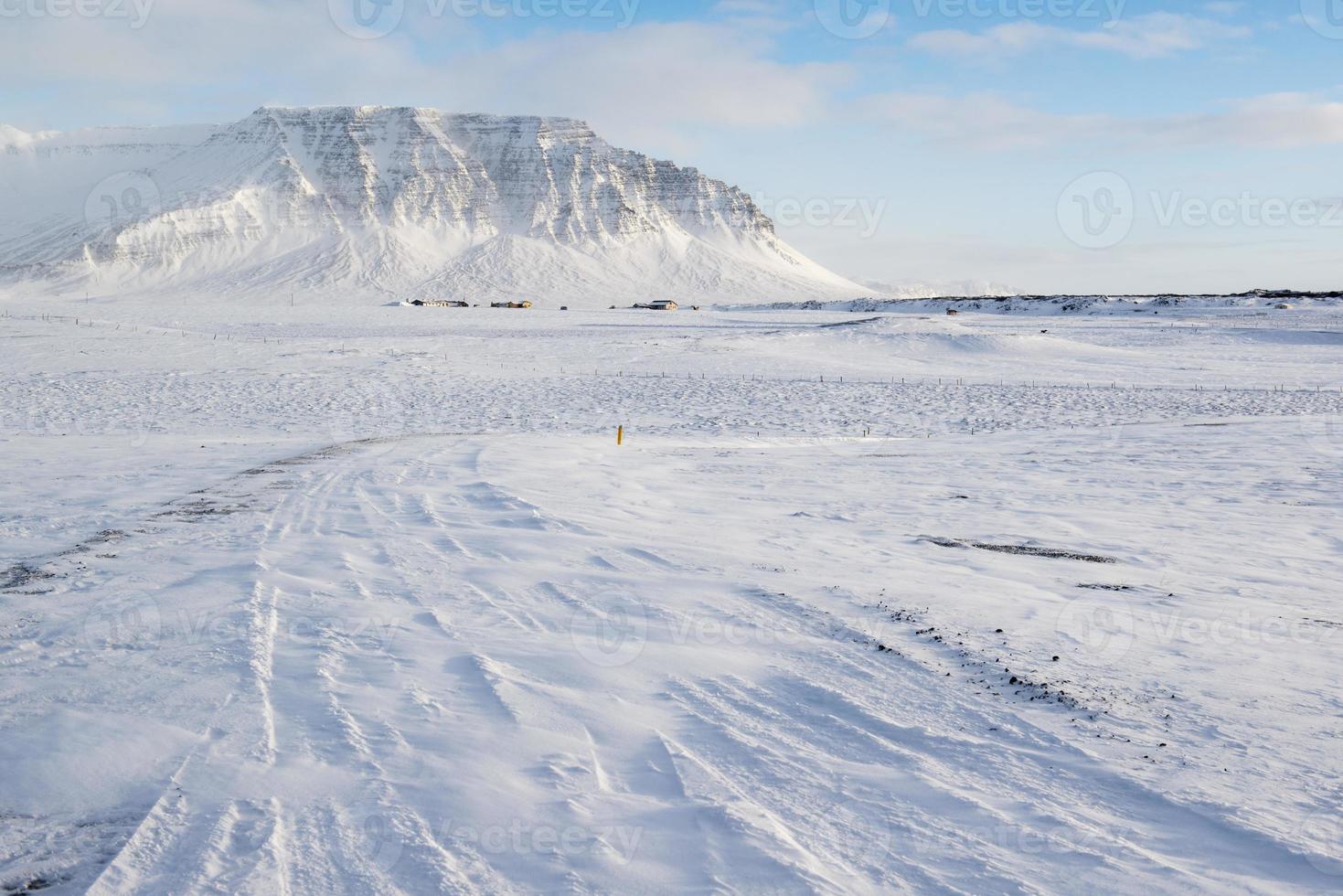 Winterlandschaft mit Bergen, Schnee und kleinen Bauernhäusern, Island foto
