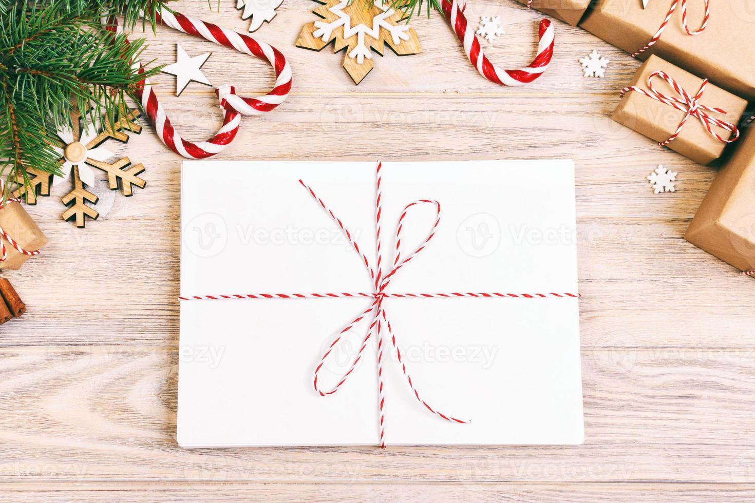 Paket im Umschlag mit Tannenzweigen und Weihnachtsdekoration auf Holzhintergrund. getönt foto