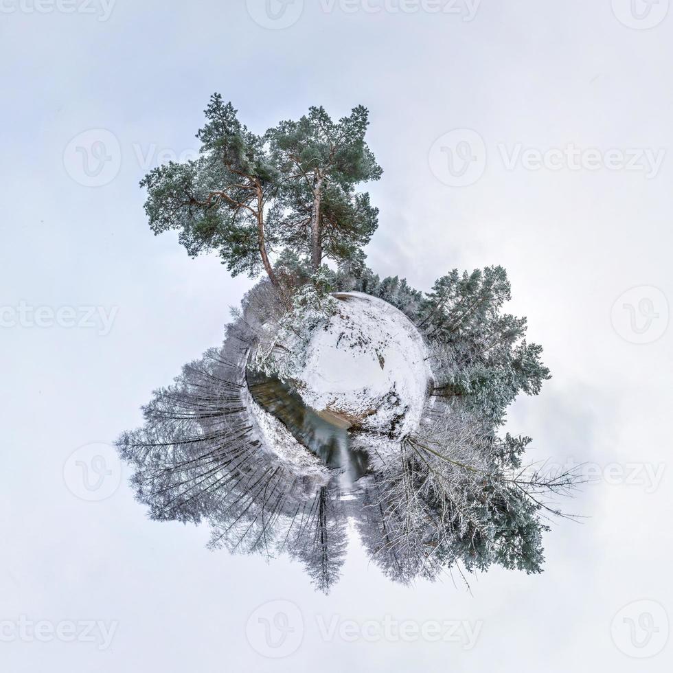 Winziger Winterplanet im schneebedeckten Pinienwald. Transformation des sphärischen Panoramas 360 Grad. sphärische abstrakte Luftaufnahme im Wald. Krümmung des Raumes. foto