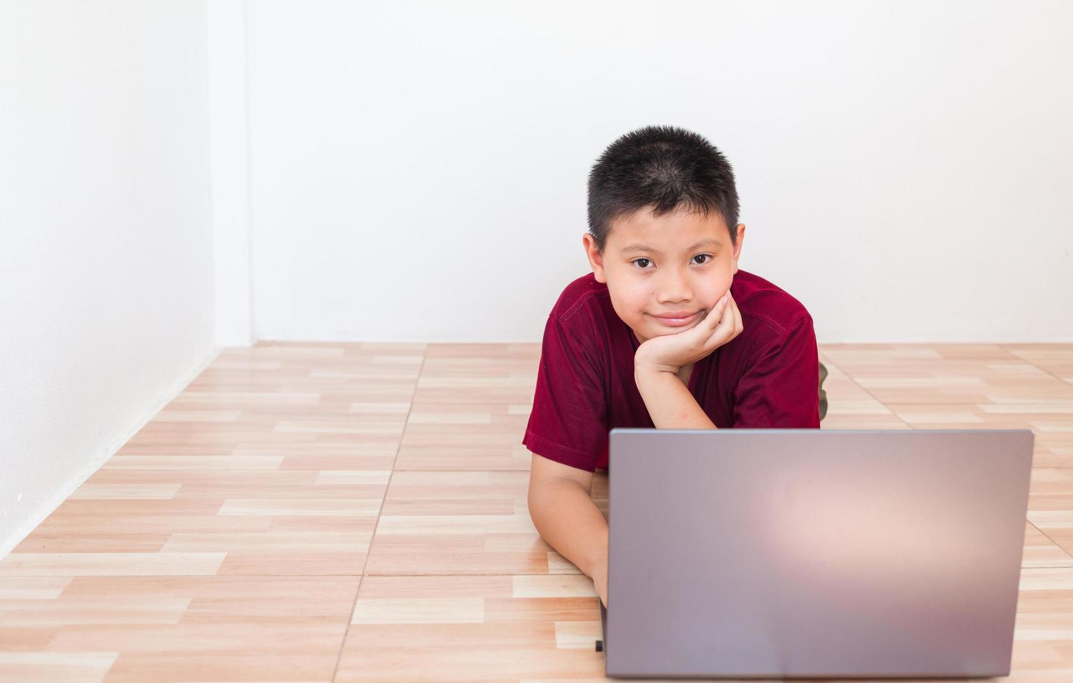 asiatischer junge, der online auf computer-laptop mit lächelndem und glücklichem gesicht zu hause studiert. Online-Bildung und E-Learning-Konzept. foto