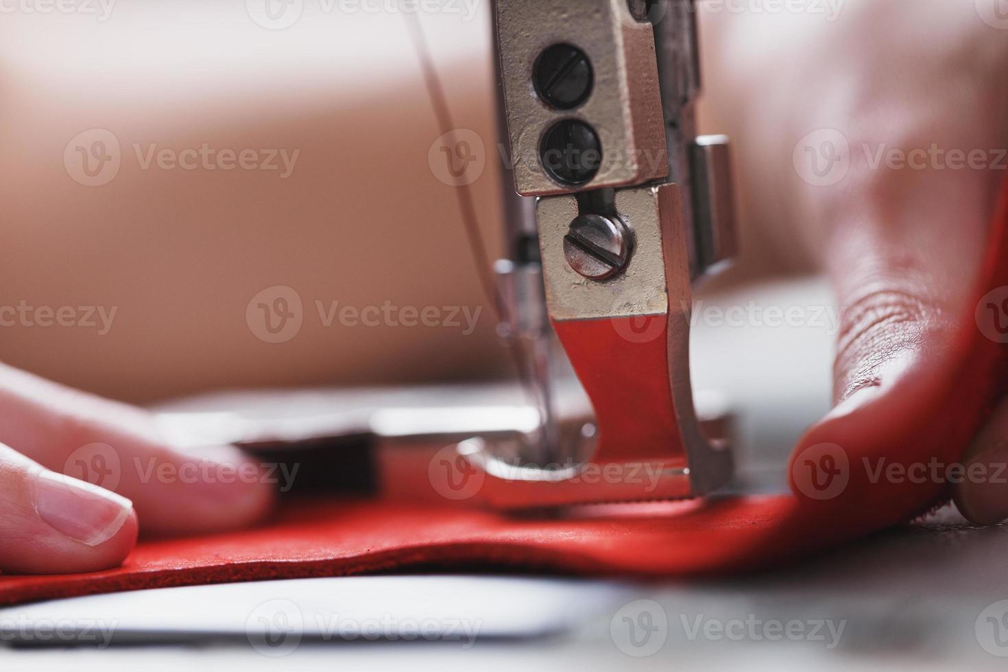 Ein Lederhandwerker stellt in seinem Geschäft Lederwaren an einer Nähmaschine her. foto