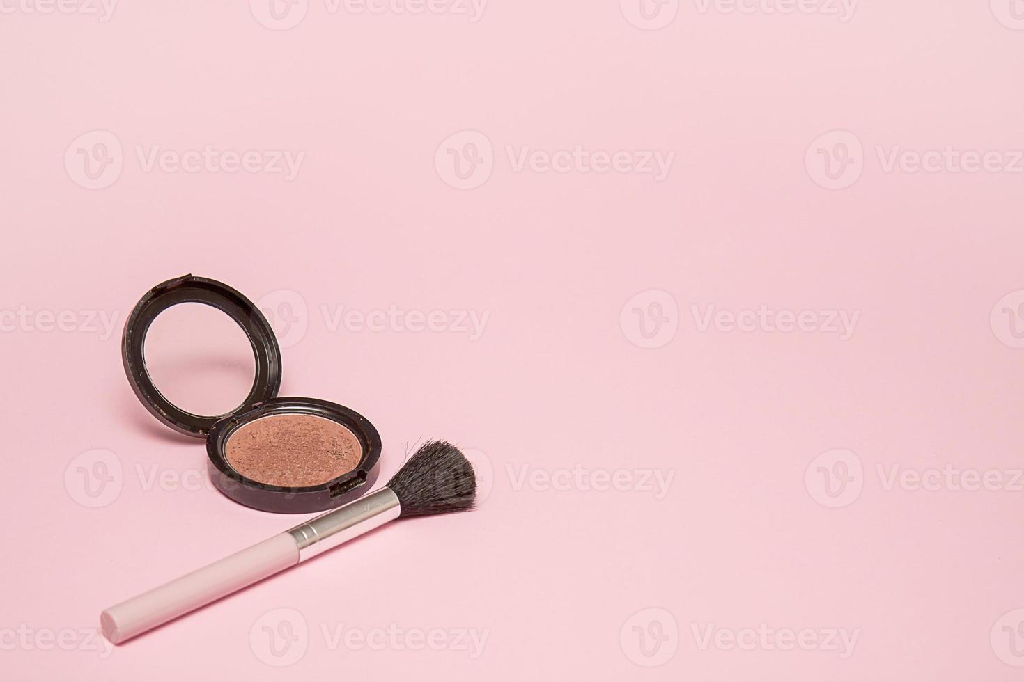erröten und make-up-pinsel auf rosa hintergrund mit kopienraum foto