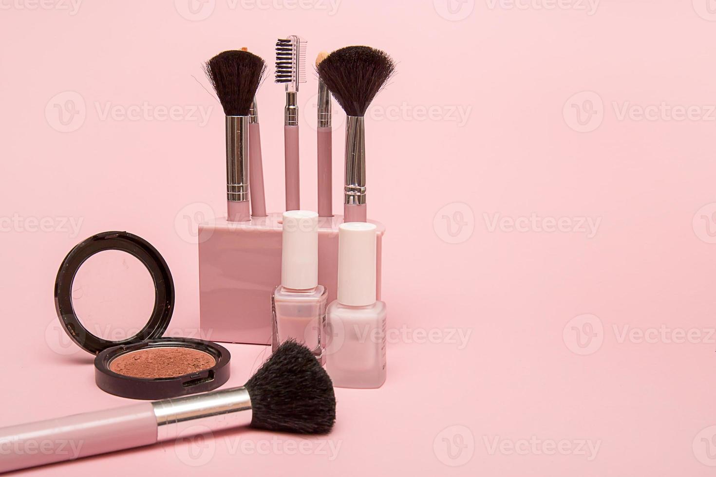 satz make-up-pinsel, nagellack, erröten auf einem rosa hintergrund mit kopienraum foto
