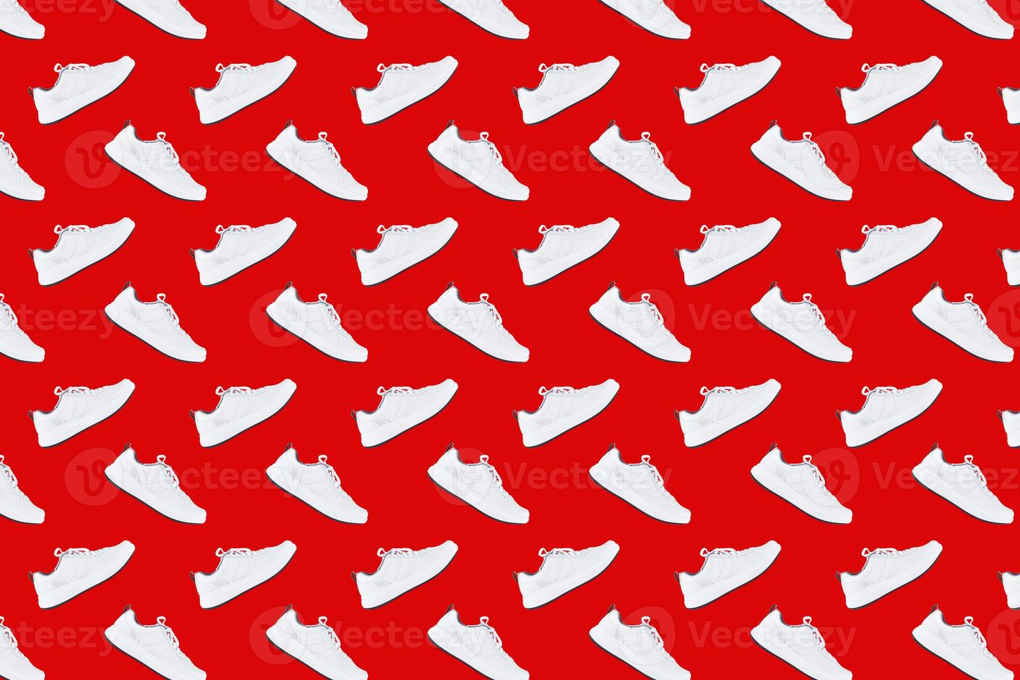 nahtloses Muster mit weißen Turnschuhen auf rotem Hintergrund foto