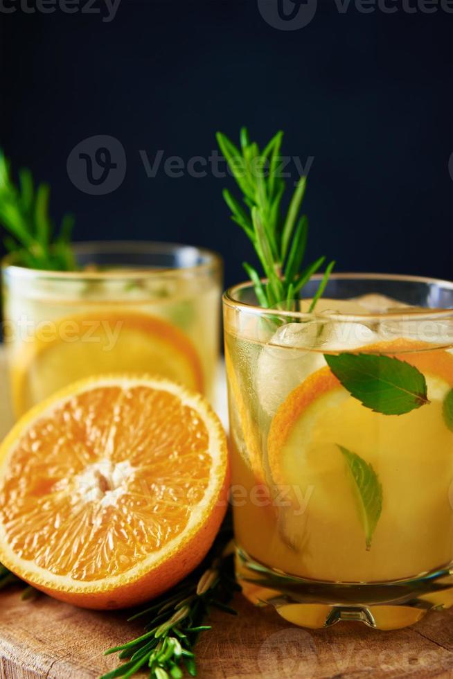 Orange frische Limonade im Glas auf dunklem Hintergrund foto