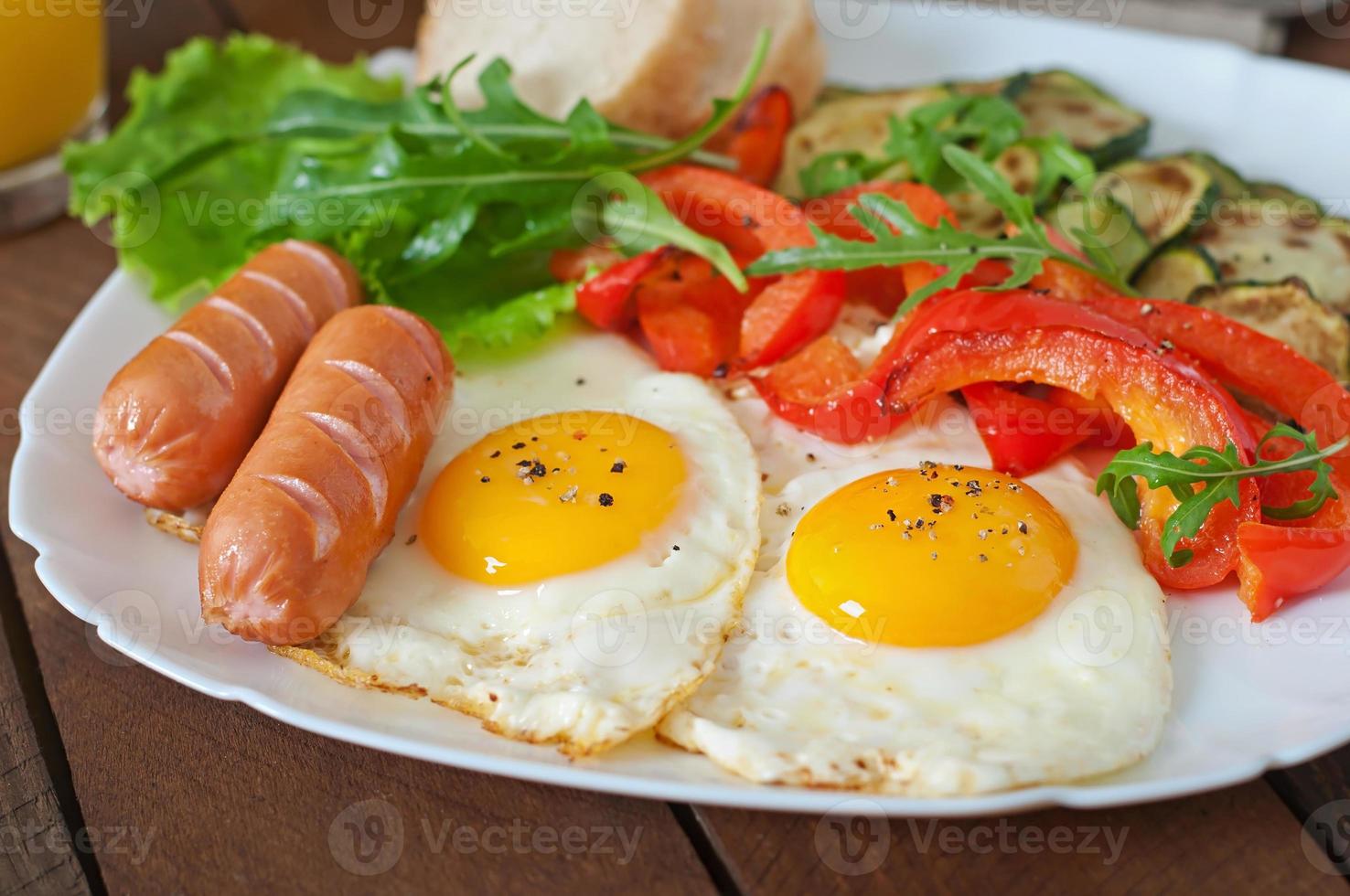 englisches Frühstück - Spiegeleier, Würstchen, Zucchini und Paprika foto