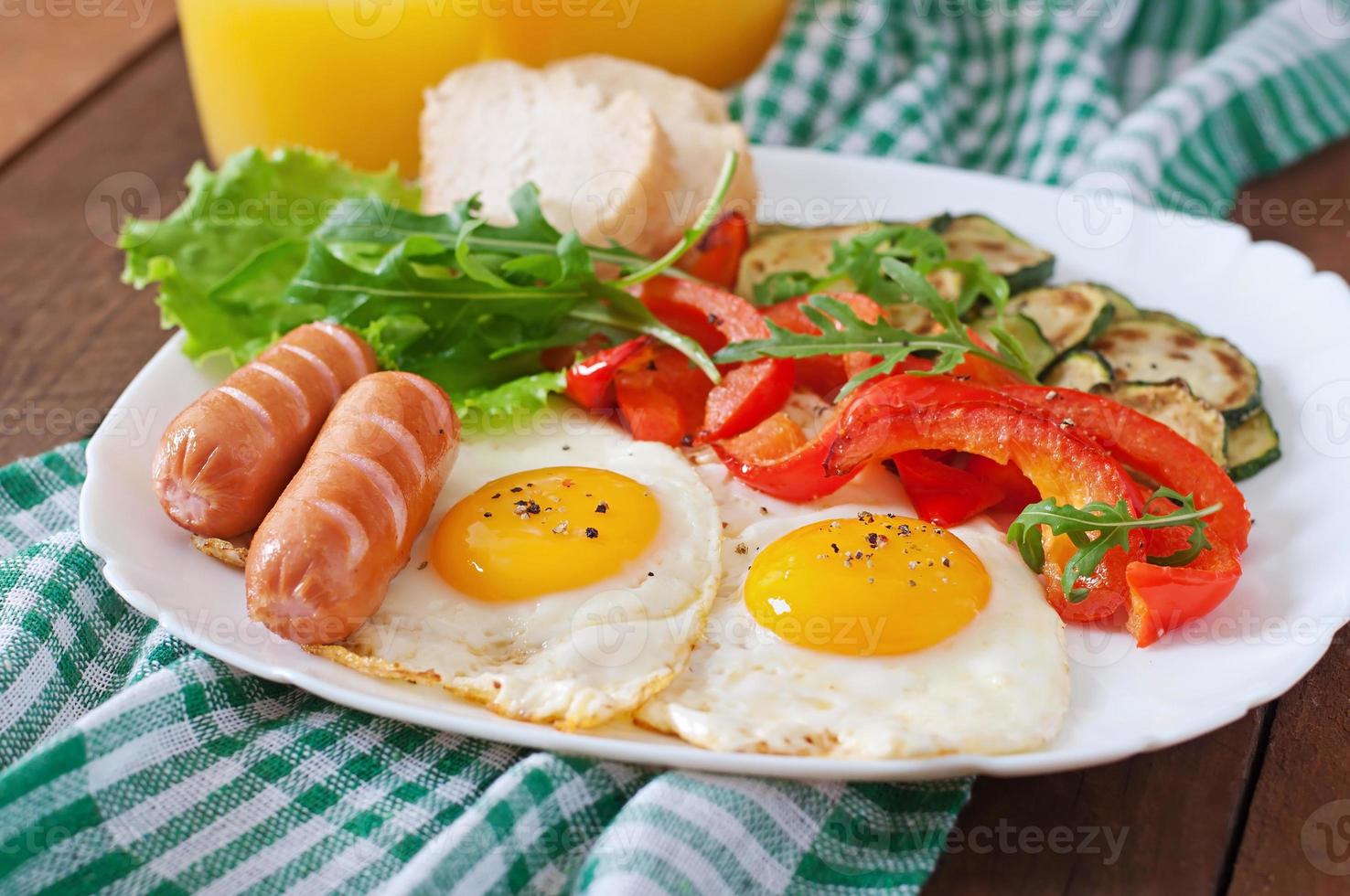 englisches Frühstück - Spiegeleier, Würstchen, Zucchini und Paprika foto