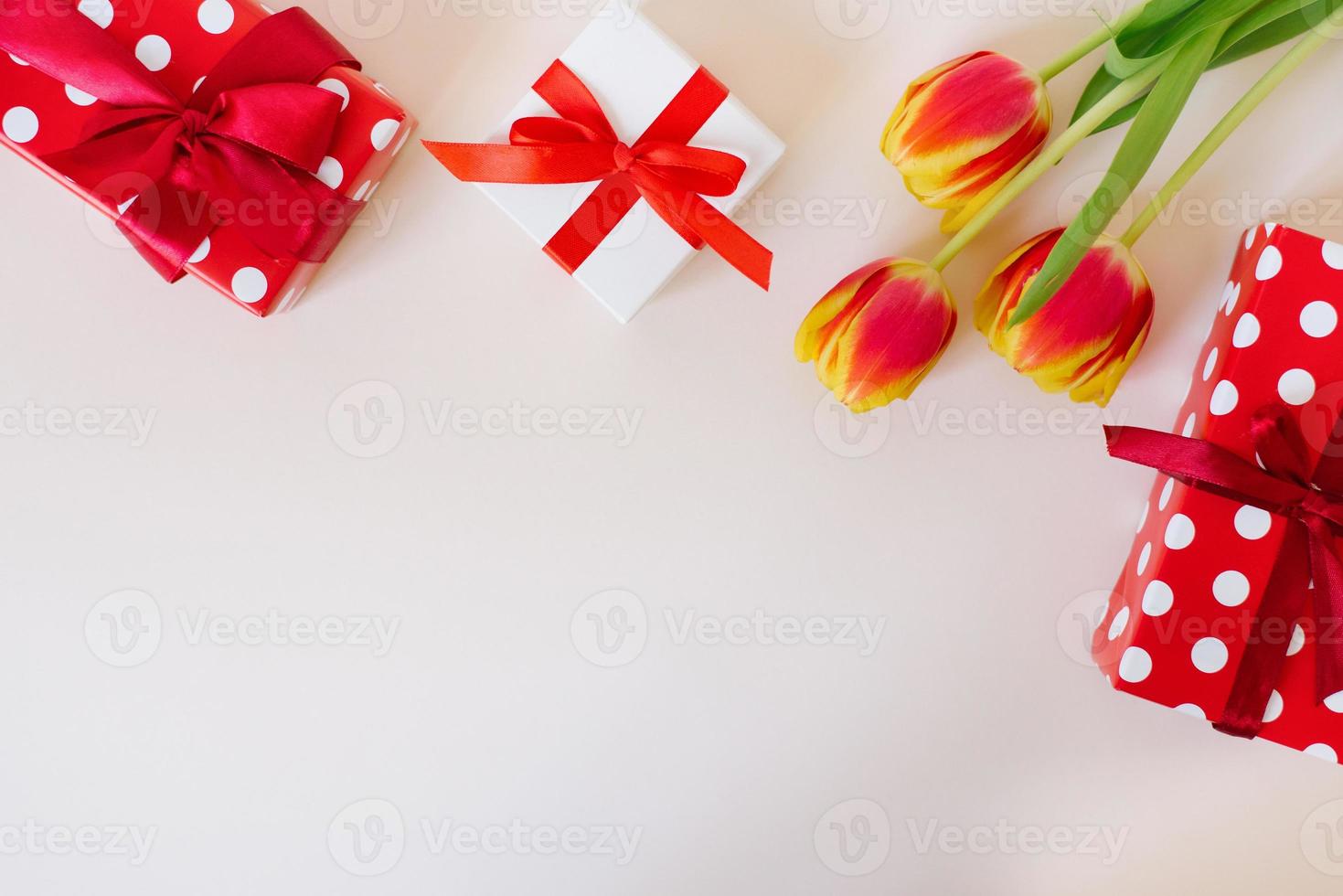 romantischer hintergrund mit blumenstrauß aus tulpen und geschenkboxen auf licht. draufsicht mit kopierraum. muttertag und valentinstag hintergrund. foto