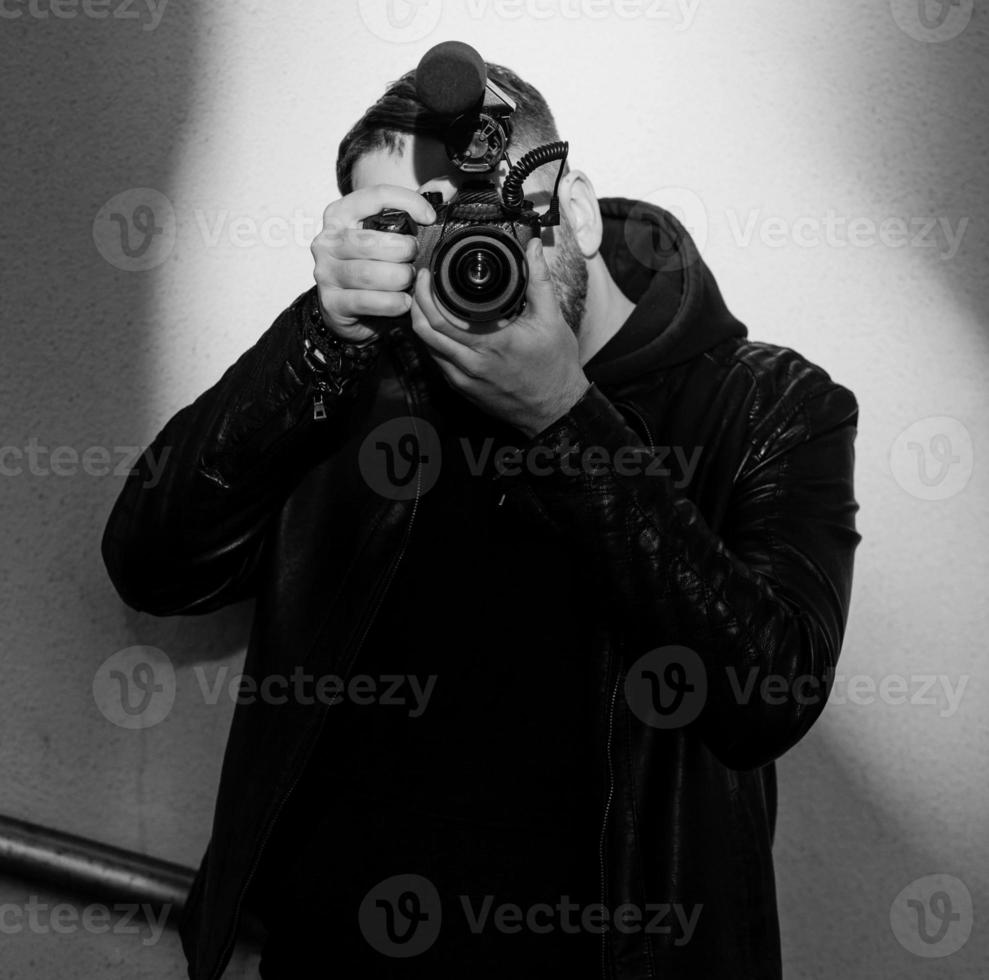 Stilvoller Mann hält eine Videokamera foto