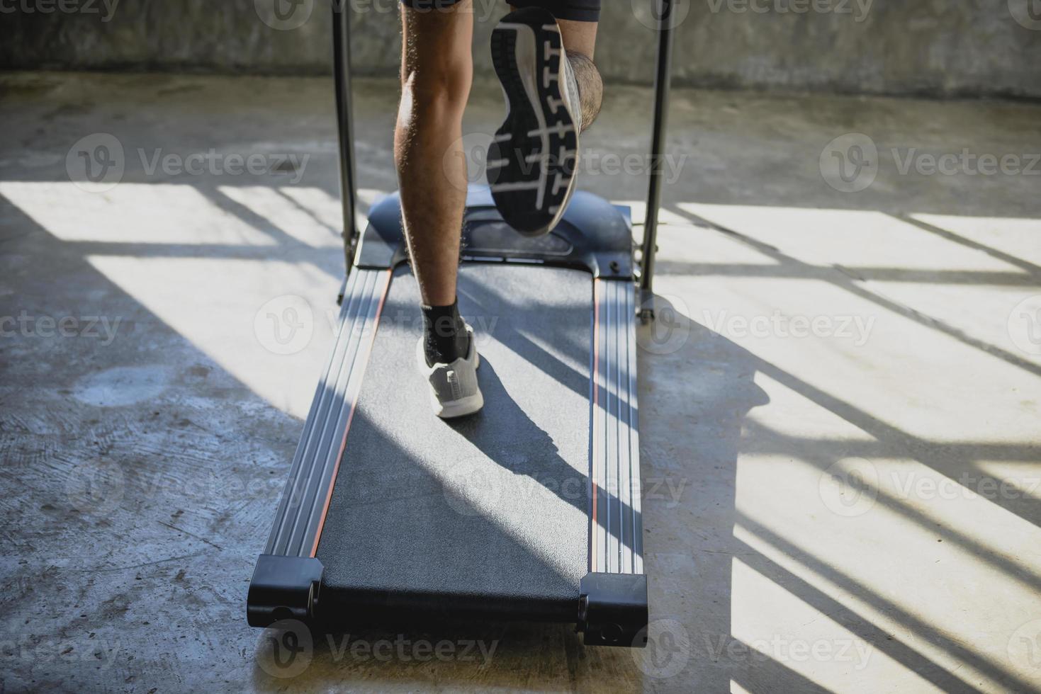 ein Mann, der auf einem Laufband läuft und trainiert. foto