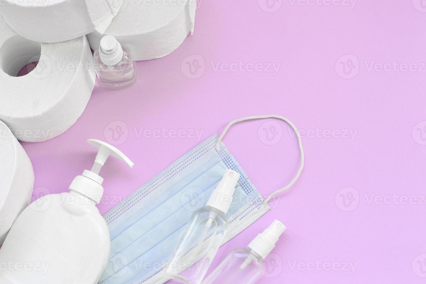 satz wichtiger gegenstände für covid-19-quarantänezeiten. Toilettenpapier mit chirurgischer Gesichtsmaske und Händedesinfektionsmittel mit Flüssigseifenflasche auf lila Hintergrund foto