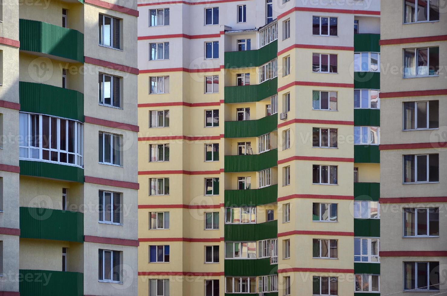neues oder kürzlich fertiggestelltes mehrstöckiges Wohngebäude mit Fenstern und Balkonen. russische Art des Hausbaus foto