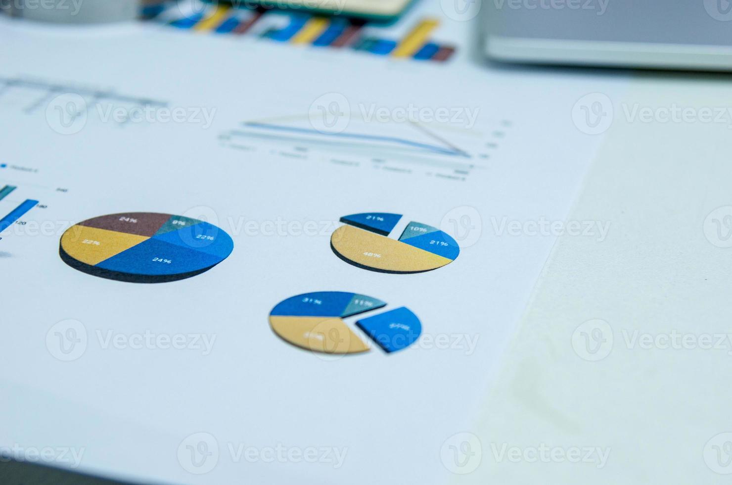 geschäftsdokumente grafiken und diagramme dokumentieren die finanzielle entwicklung, bankkonten, statistiken, auf dem schreibtisch im büro. foto