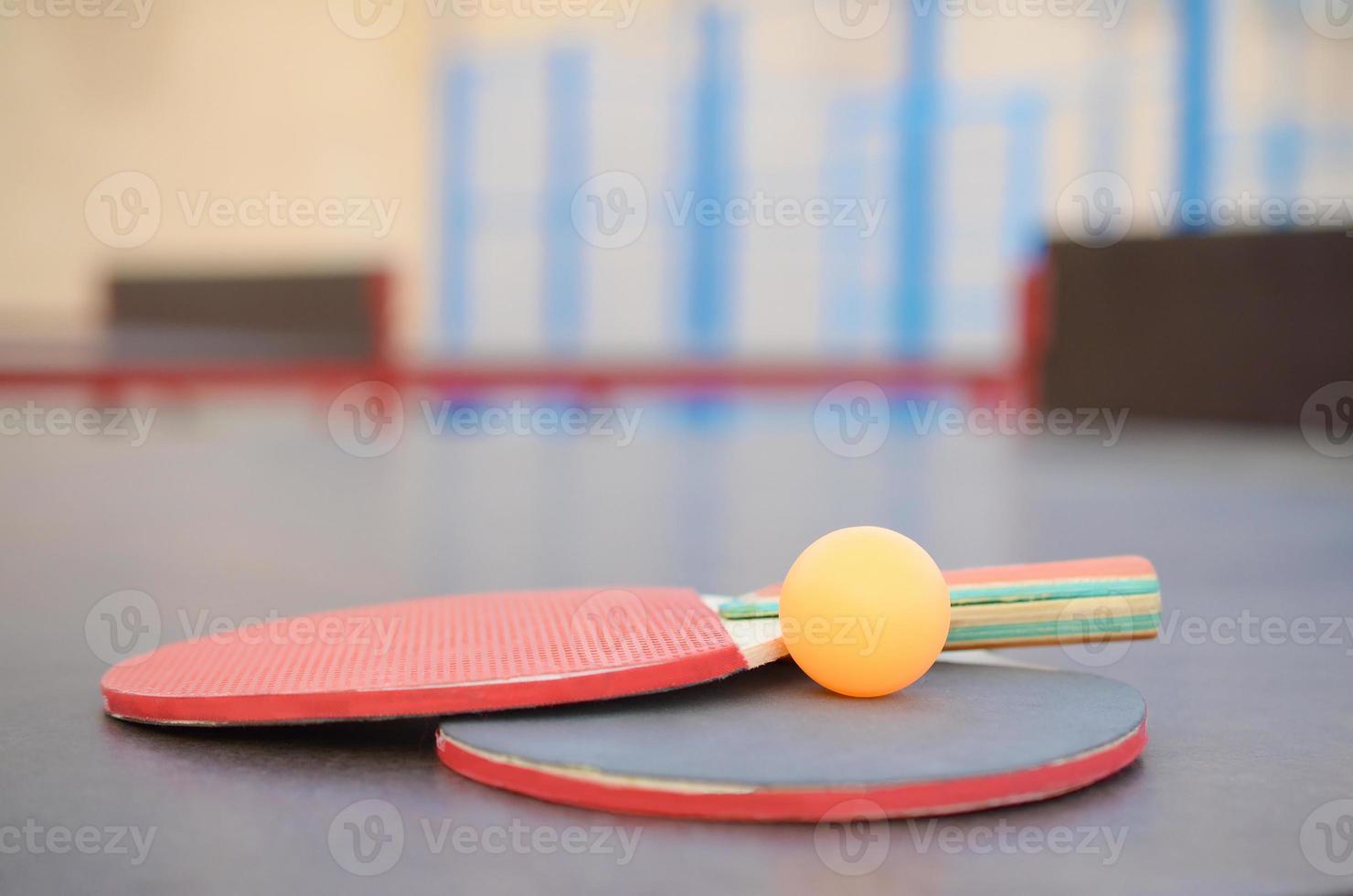 Schläger und Ball auf der Tischtennisplatte im Sporthof im Freien. aktives sport- und körperliches trainingskonzept foto