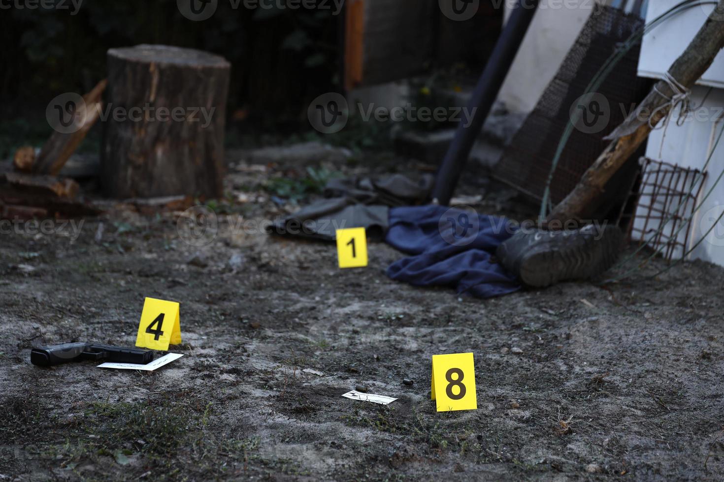 beweis mit gelbem csi-marker zur beweisnummerierung auf dem wohnhinterhof am abend. Tatortuntersuchungskonzept foto