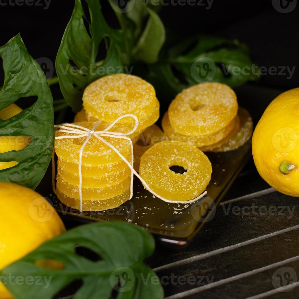 Zitronen-, Orangen- und Grapefruitscheiben in Zucker isoliert auf Holzhintergrund, Nahaufnahme. Marmelade Süßigkeiten. Süßigkeiten mit Zitrusgeschmack. Süßigkeiten foto