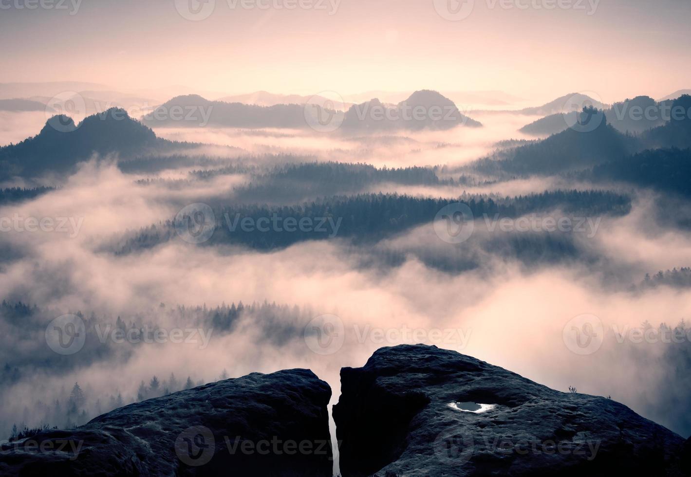 verträumter Tagesanbruch auf dem felsigen Berg mit Nebel foto