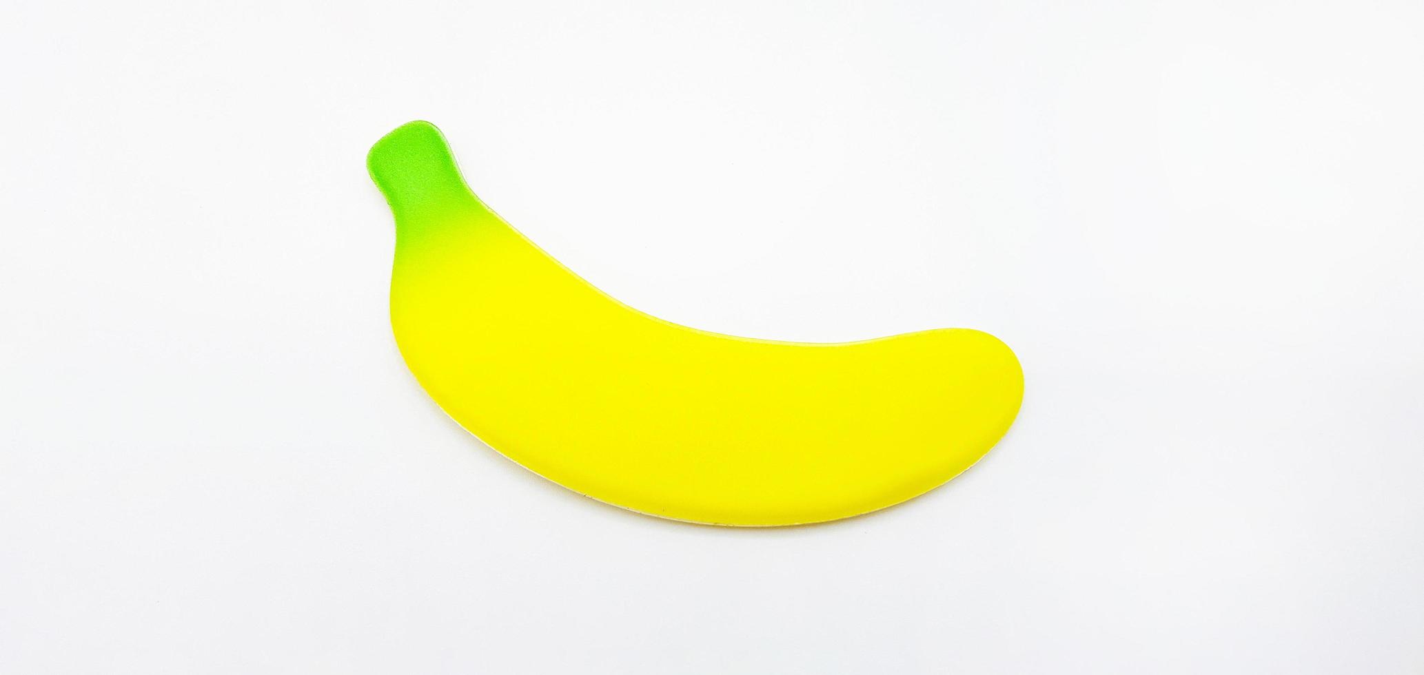 gefälschte Banane isoliert auf weißem Hintergrund. kleines Spielzeug, Form und Objekt. Konzept. nicht echt von Obst foto