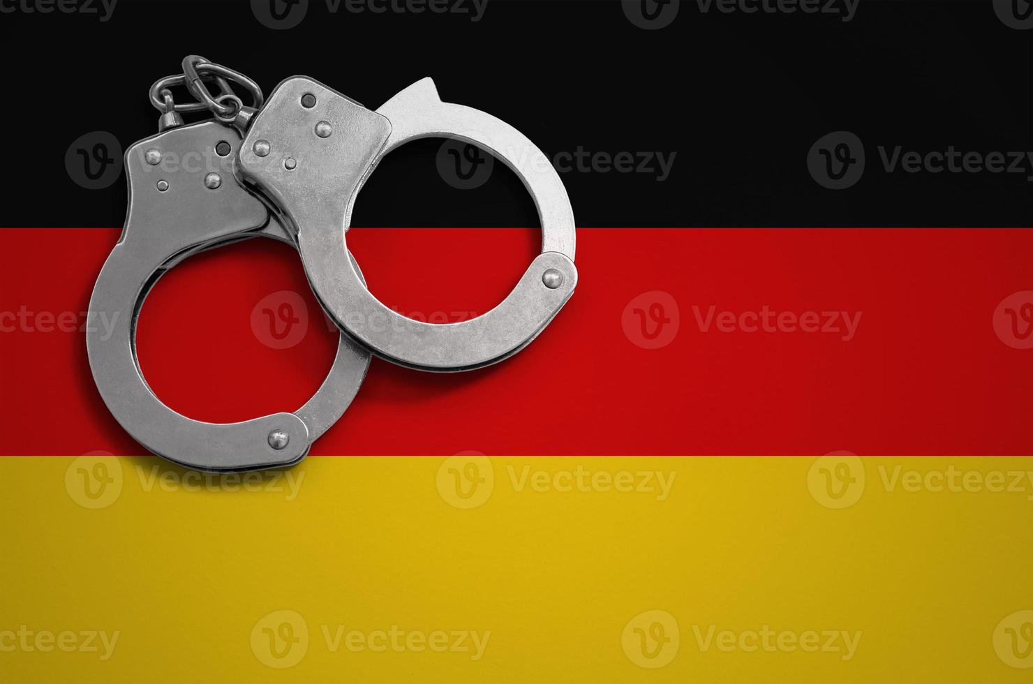 deutschlandfahne und polizeihandschellen. das Konzept der Kriminalität und Straftaten im Land foto