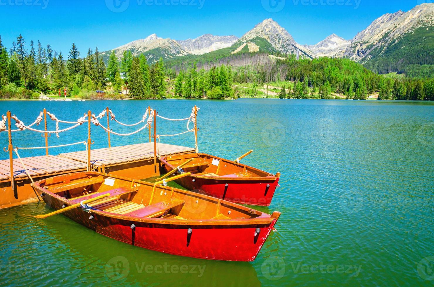 rote Holzboote auf Bergsee in der Slowakei foto