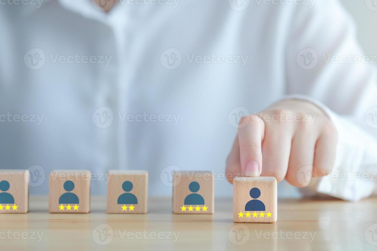 Einstellung von Unternehmen und Personalauswahl. Karrieremöglichkeiten. Personalmanagement. Hand ausgewähltes menschliches Symbol mit 5 Sternen auf Holzblock. Wahl des Mitarbeiterführers von vielen Menschen. foto