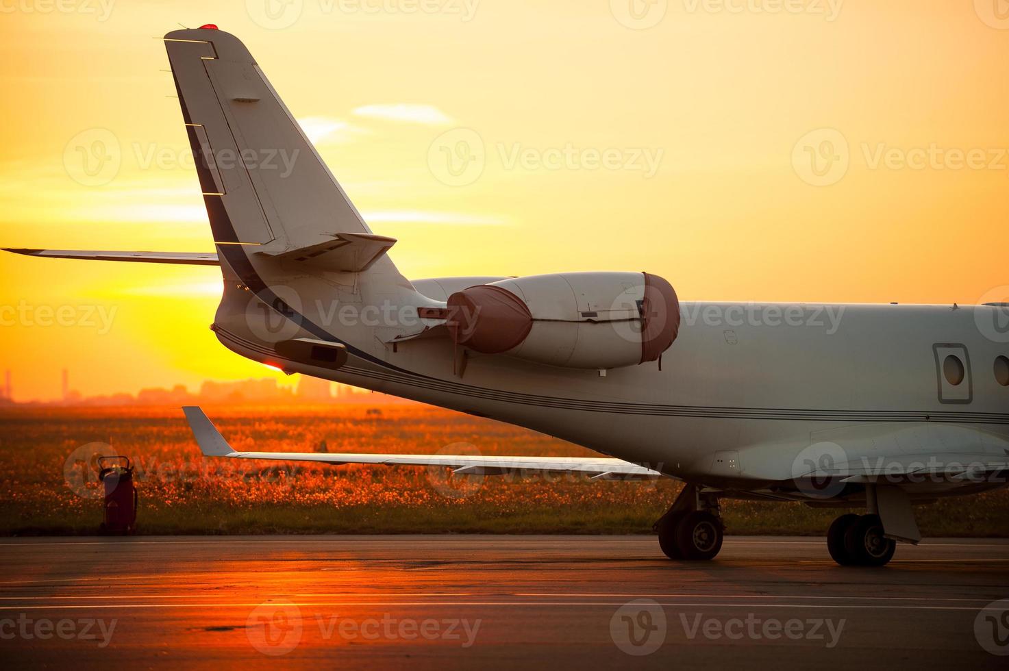 bereit zum Flug. Zugeschnittenes Bild eines Flugzeugs, das auf dem Flughafen landet, mit Sonnenuntergang im Hintergrund foto