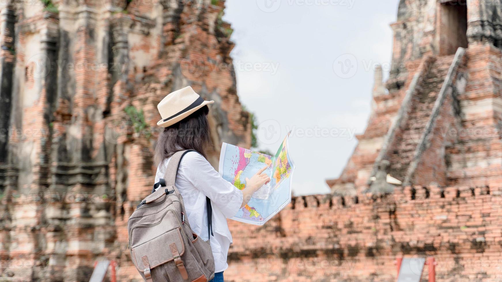 hipster-reisende mit rucksack, der karte hält und den tempel erkundet, reisekonzept, platz für text. Fernweh foto